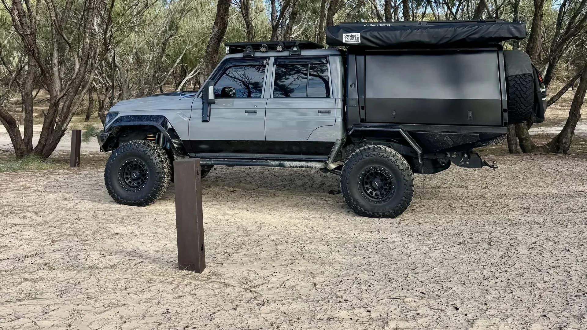 Drewsy's 79 side on at a sandy bush track, canopy and roof rack in view.