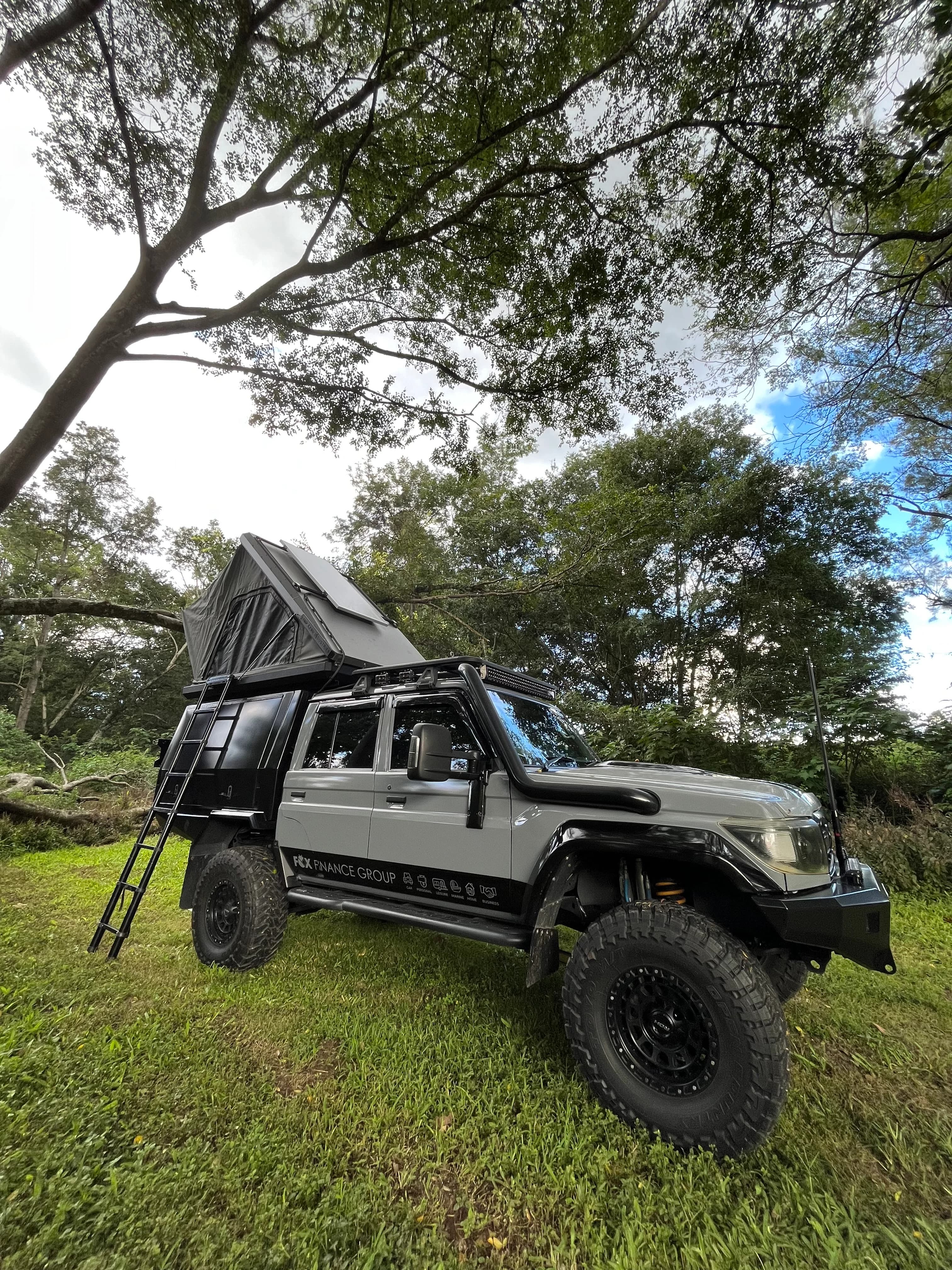 Drewsy's 79 with the hard-shell rooftop tent up and the ladder down.