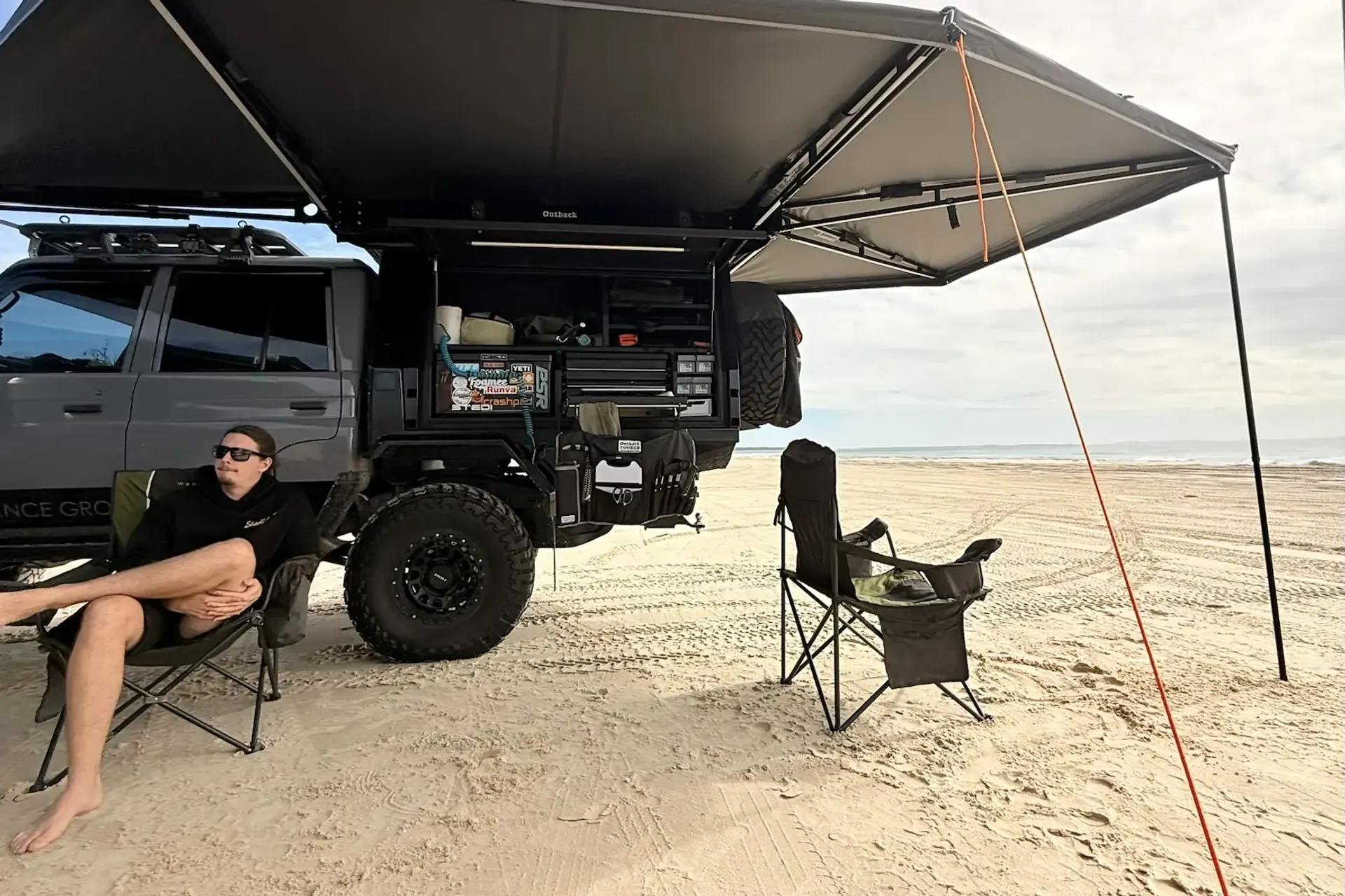 Kicking back under the awning beside Drewsy's 79 on the beach.